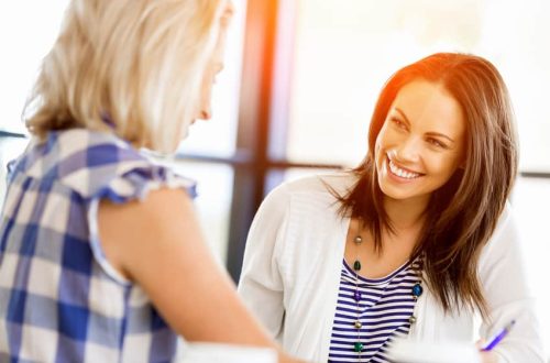 Two young business women working together in office